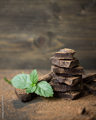 Dark chocolate with mint sprinkled with cocoa powder on a wooden surface