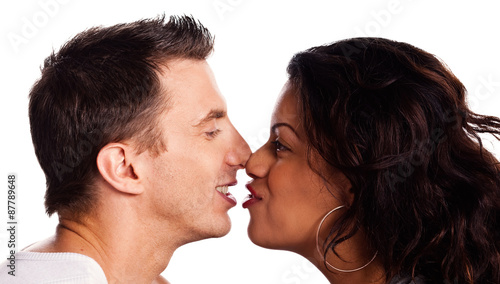 Portrait of a mixed racial couple rubbing noses on a white backg