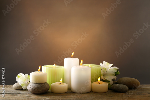 Beautiful composition with candles and spa stones on dark background