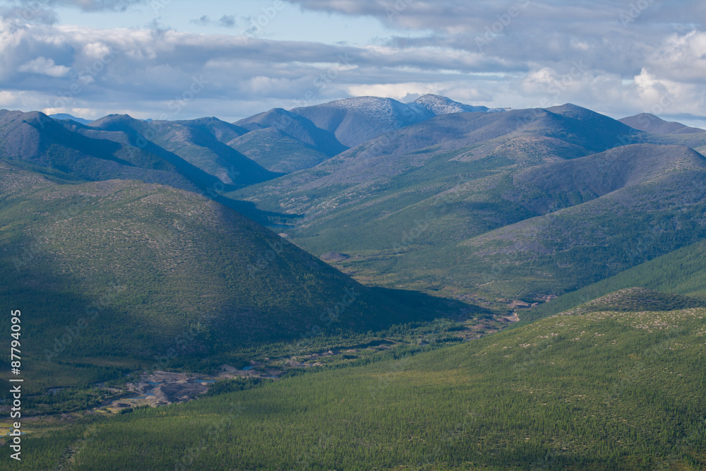 River valley among green slopes in Magadan area