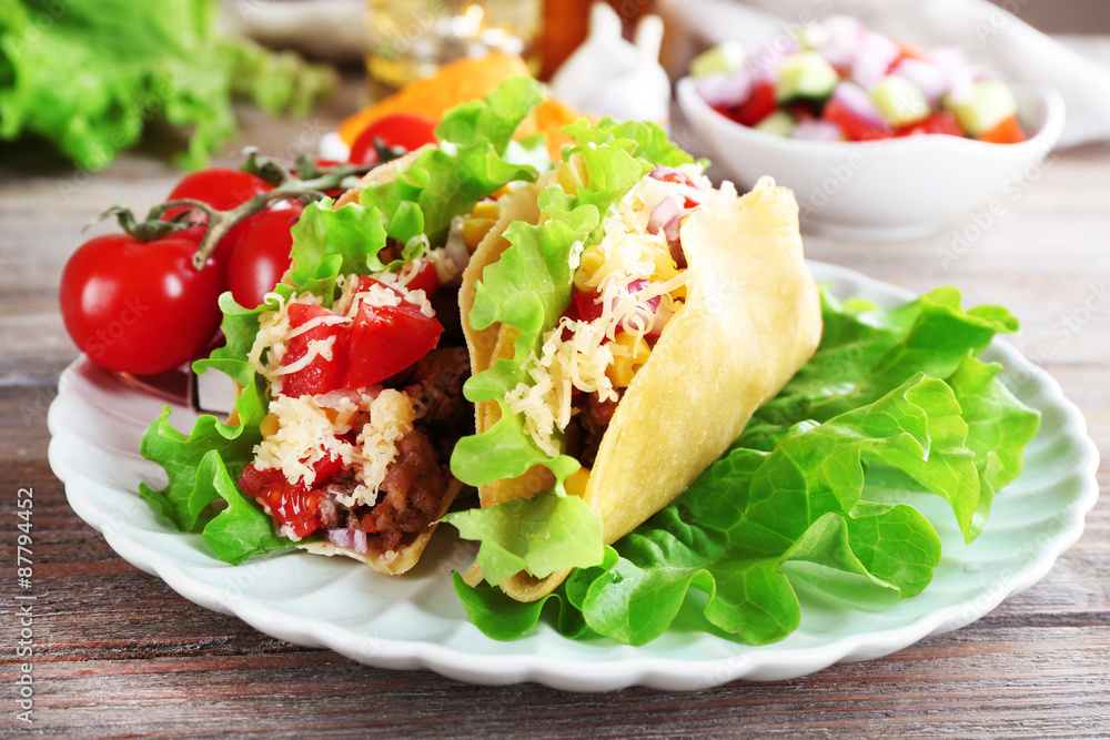 Tasty taco with vegetables on plate on table close up Tasty taco with vegetables on plate on table close up