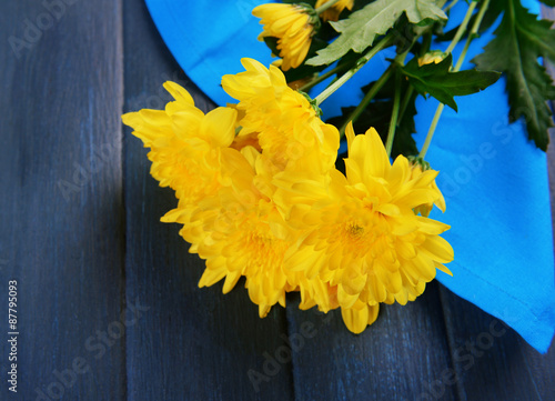 Beautiful bouquet of yellow chrysanthemum with napkin on wooden table