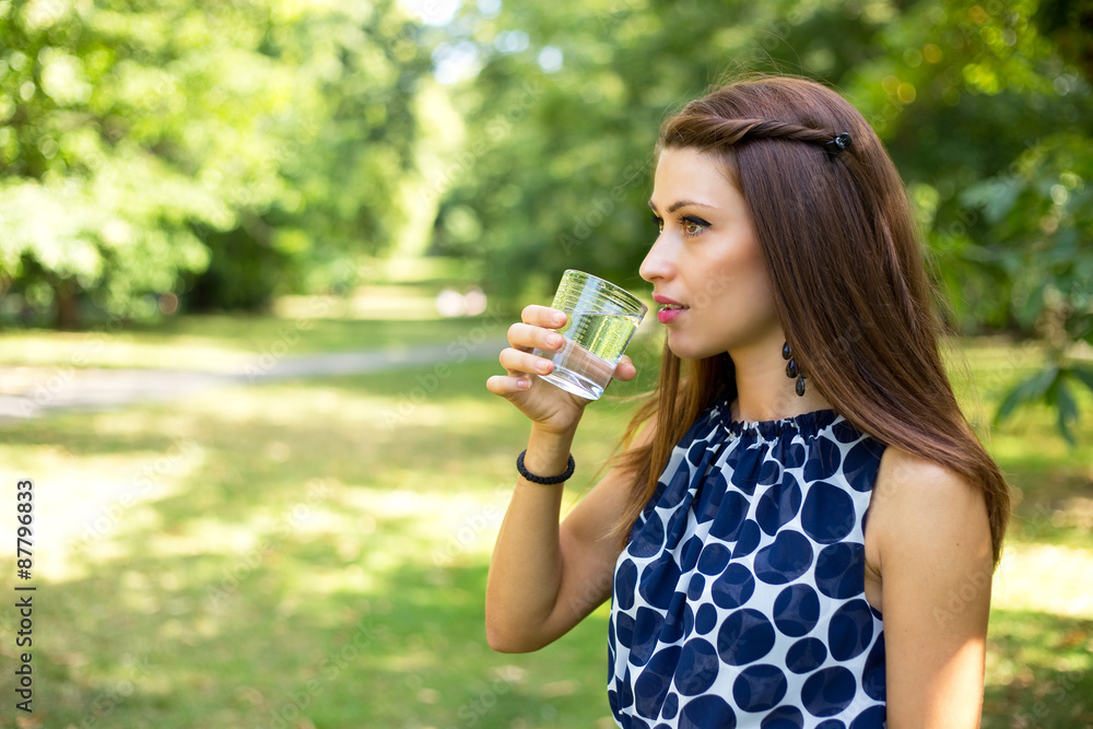 young woman drinking a glass of water outdoors young woman drinking a glass of water outdoors