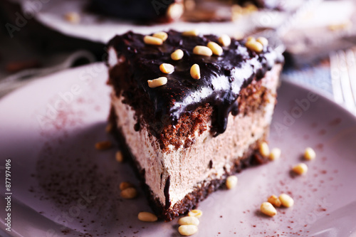 Delicious chocolate cake with icing in plate on table  closeup