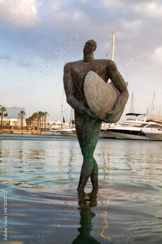 Alicante, Spain - July 02, 2015: The statue of a surfer in the bay of Alicante is about promenades.