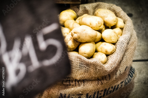 fresh potatoes in burlap sack selling in market