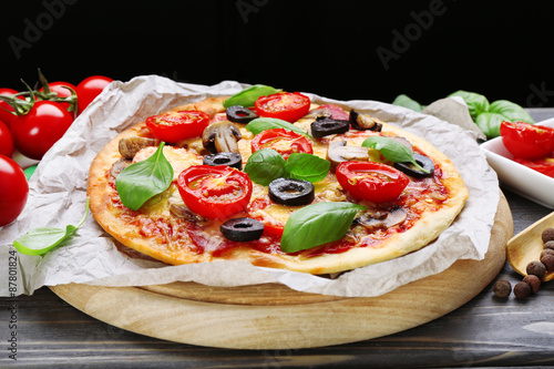 Tasty pizza with vegetables and basil on table close up