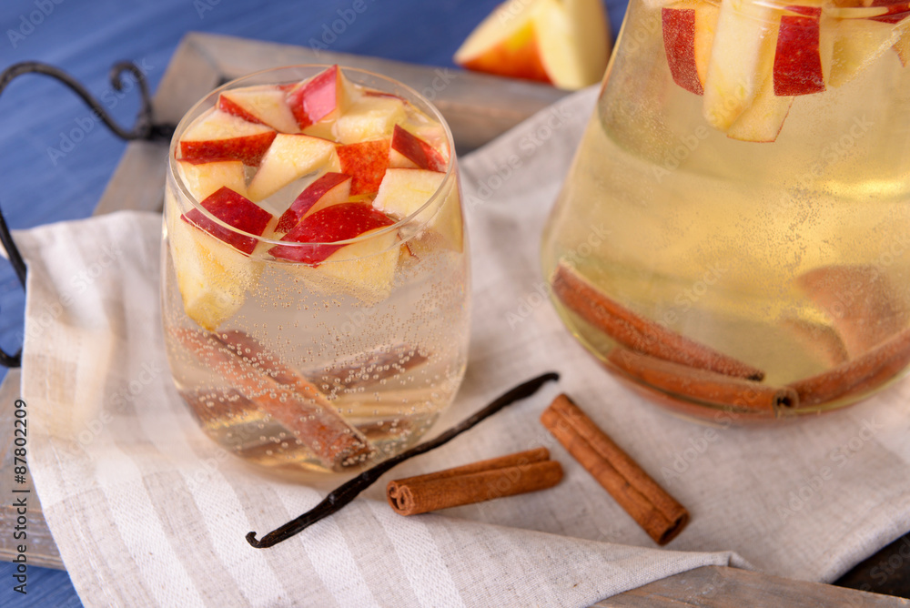 Glass and carafe of apple cider with fruits and spices on table close up Glass and carafe of apple cider with fruits and spices on table close up