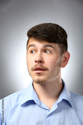 Portrait of surprised man on gray background © Africa Studio