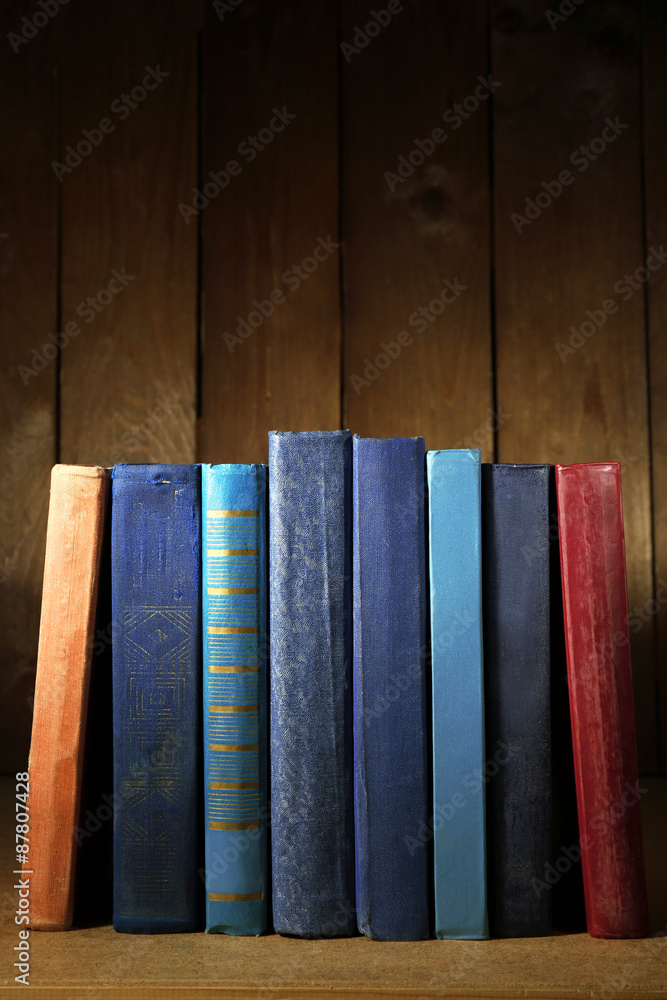 Old books on shelf, close-up, on dark wooden background Old books on shelf, close-up, on dark wooden background