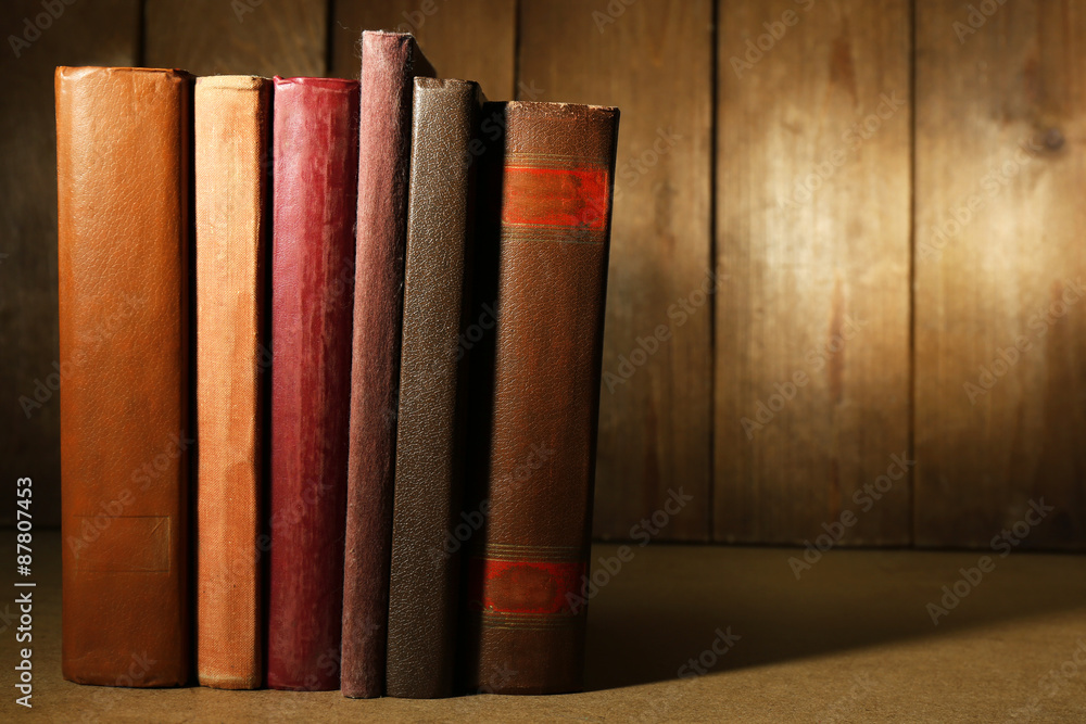 Naklejka premium Old books on shelf, close-up, on dark wooden background