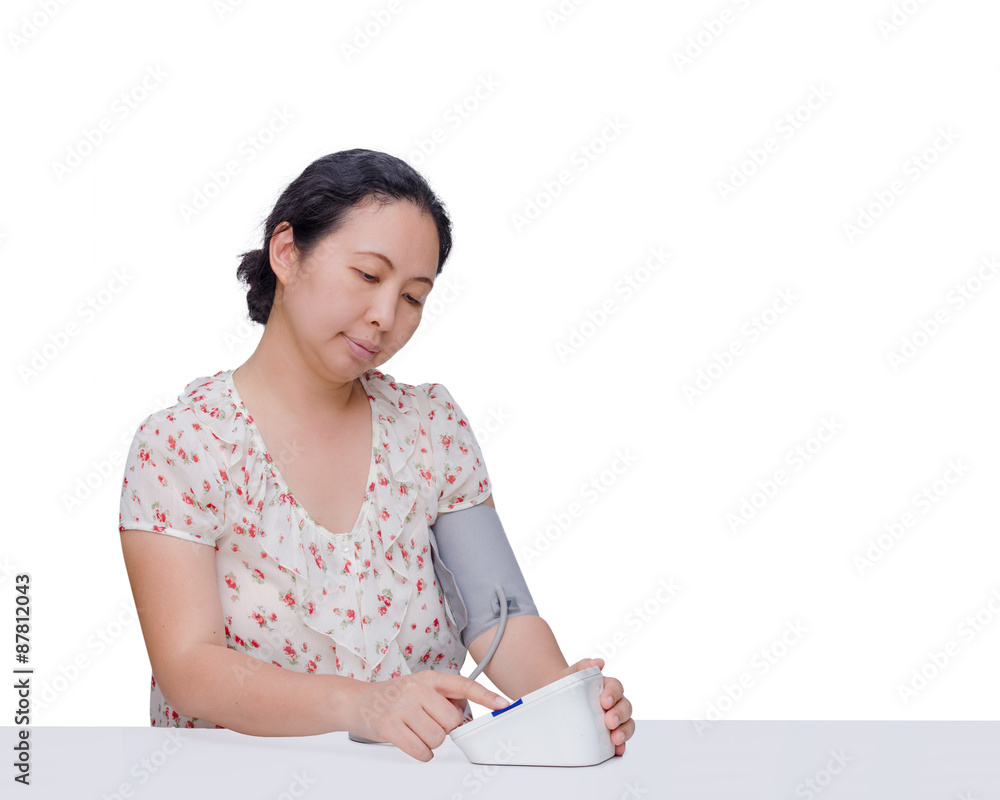 Asian woman checking her blood pressure by herself Asian woman checking her blood pressure by herself