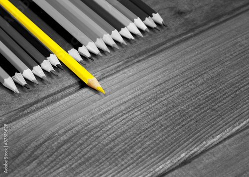 Black and white image of colored pencils with isolated yellow pe