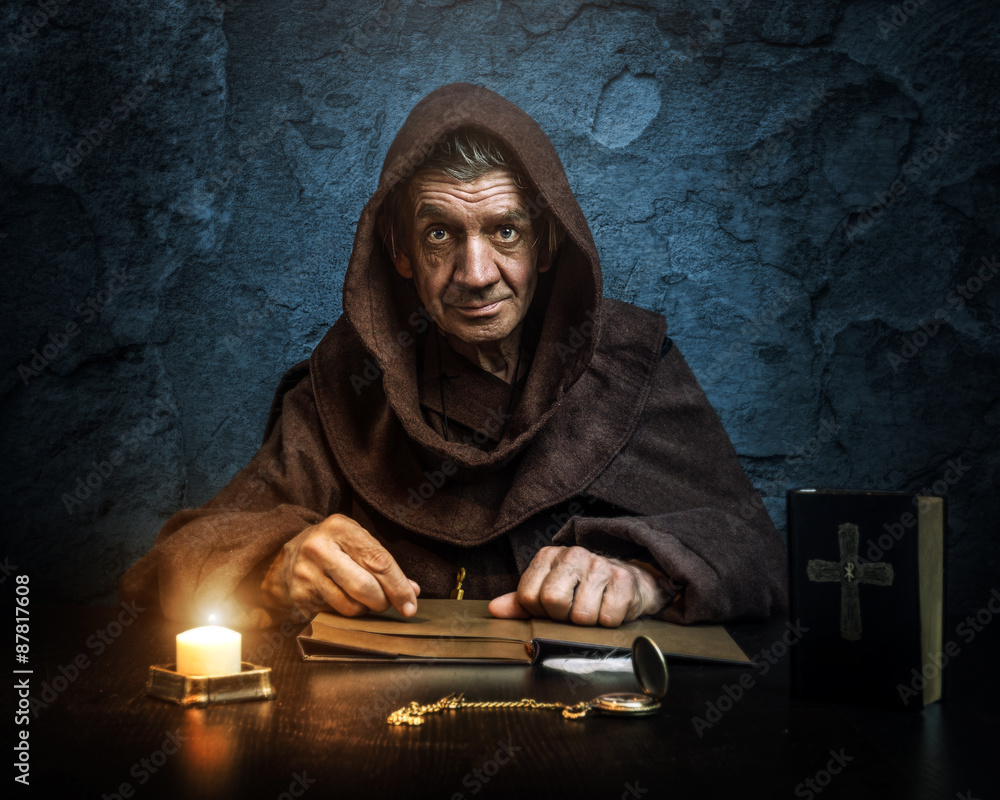 .Monk priest.by candlelight Bible reading foto de Stock Adobe Stock