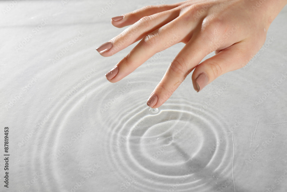 Obraz premium Female hand touching water surface