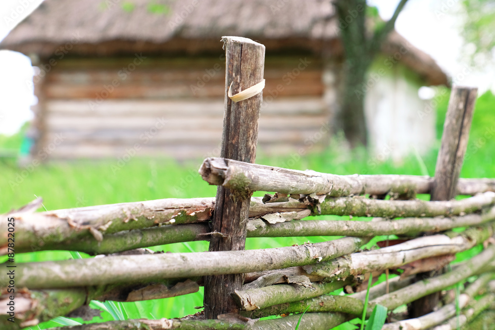 Wicker rustic fence in garden on grass background Wicker rustic fence in garden on grass background