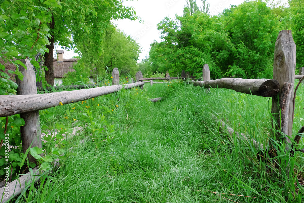 Fototapeta premium Wooden fence on nice green meadow