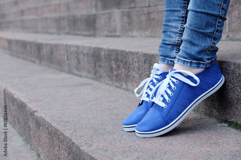 Female feet in gumshoes on  stone stairs