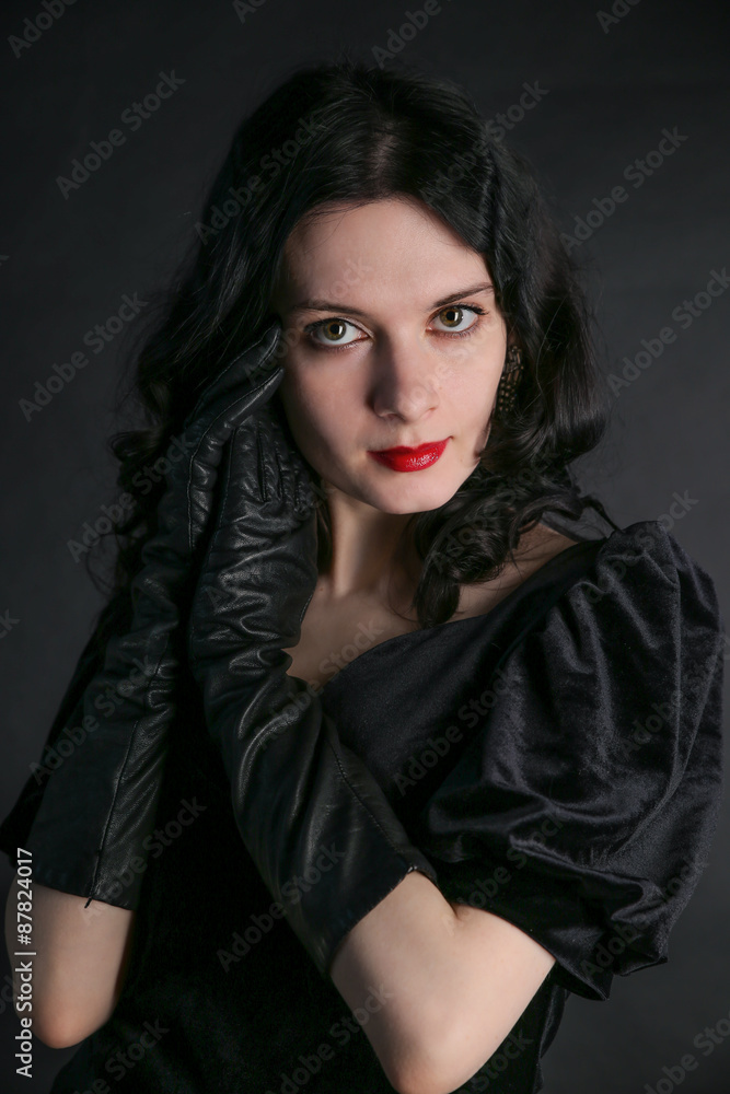 Beautiful trendy girl with fashionable makeup wearing a black dress in a studio Beautiful trendy girl with fashionable makeup wearing a black dress in a studio