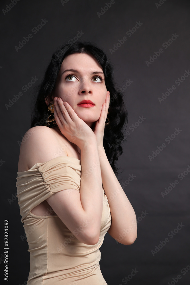 Portrait of beautiful young woman sitting over black background Portrait of beautiful young woman sitting over black background