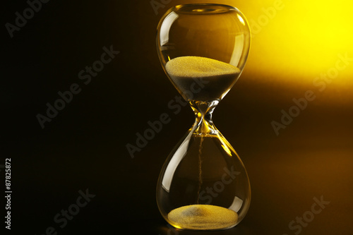 Hourglass on dark yellow background