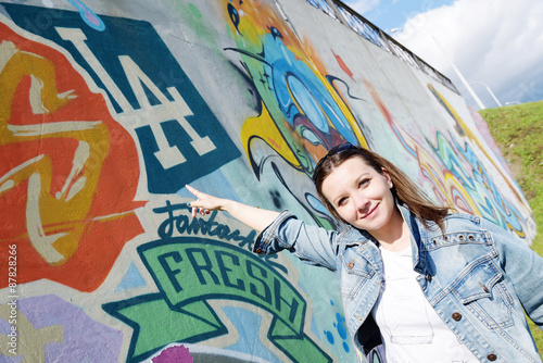 girl in sunglasses near graffiti wall