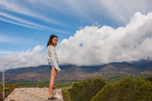 Female pre-teen looking over majestic valley.