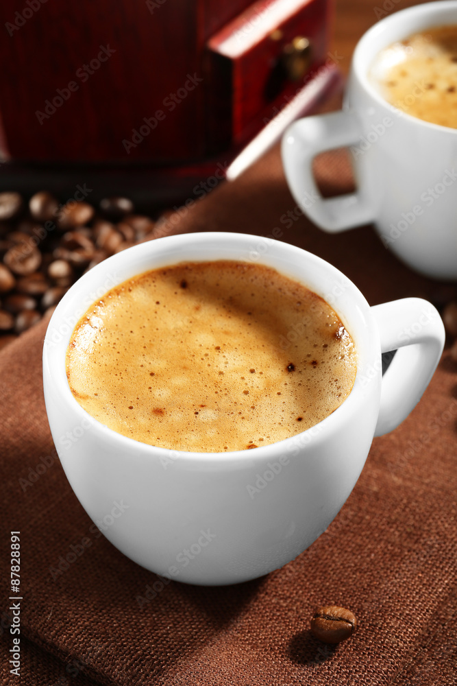 Obraz premium Two cups of fresh coffee with beans on table, closeup