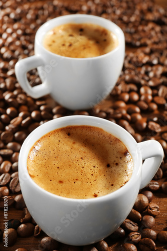 Two cups of fresh coffee with beans on table, closeup © Africa Studio