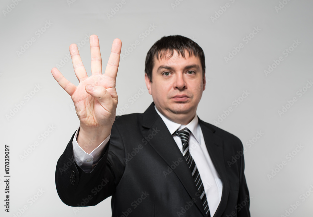Portrait of a businessman showing four fingers Portrait of a businessman showing four fingers