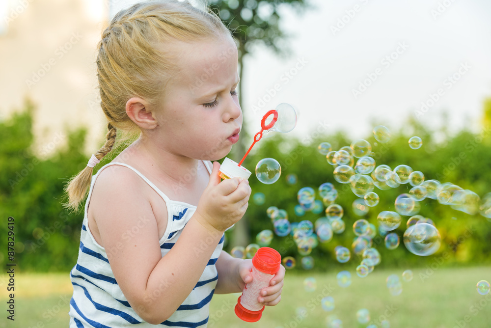 Sympathetically playing girl and her soap bubbles