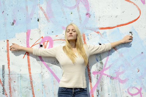 Junge Frau steht an Mauer, Berlin, Deutschland
