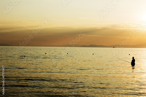 Fototapeta Naklejka Na Ścianę i Meble -  Fisherman in the sea at sunset
