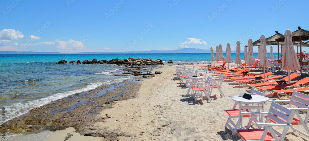 Beautiful white sand beach with sun beds, tables, chairs and par Beautiful white sand beach with sun beds, tables, chairs and par