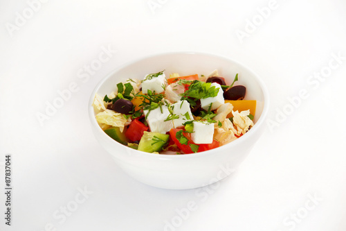 Bowl of fresh greek salad isolated at white background