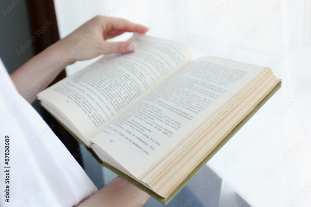 Fototapeta premium Woman reading book near window