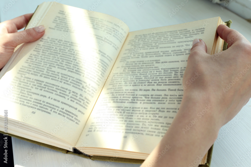 Fototapeta premium Woman reading book near window