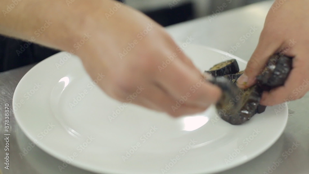 Chef puts on a plate baked zucchini and eggplant Chef puts on a plate baked zucchini and eggplant