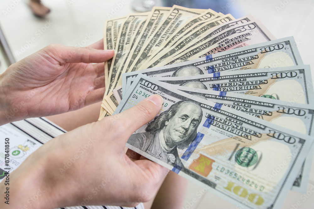 © Suwatchai - counts money in hands