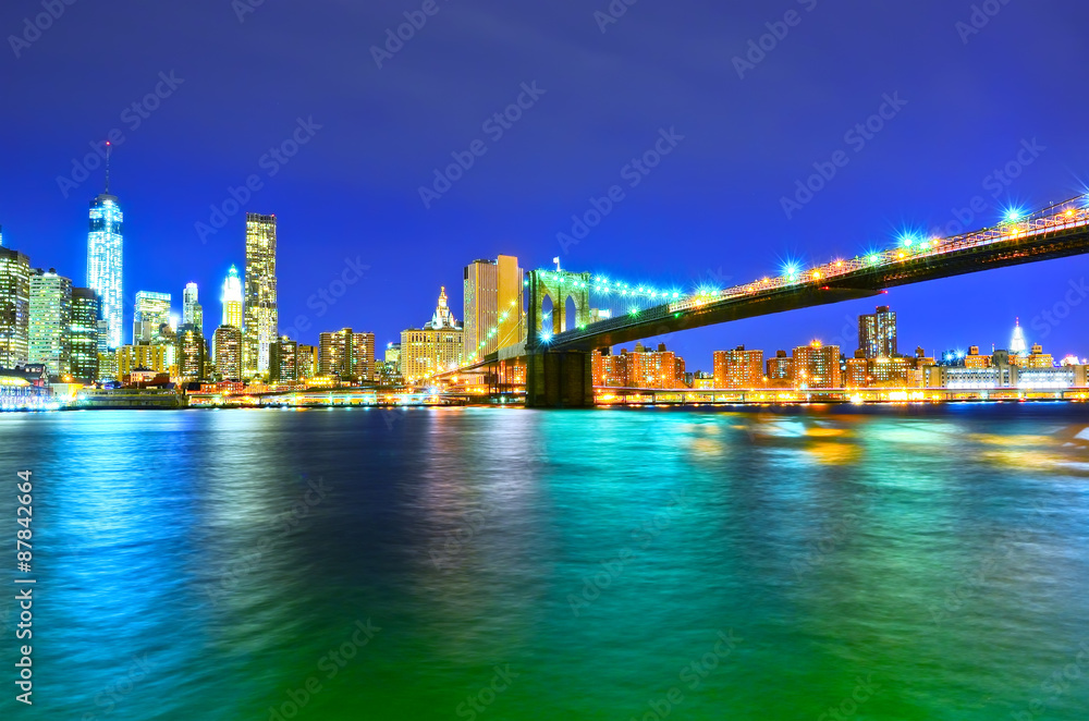 Naklejka premium Manhattan skyline and Brooklyn Bridge at night.