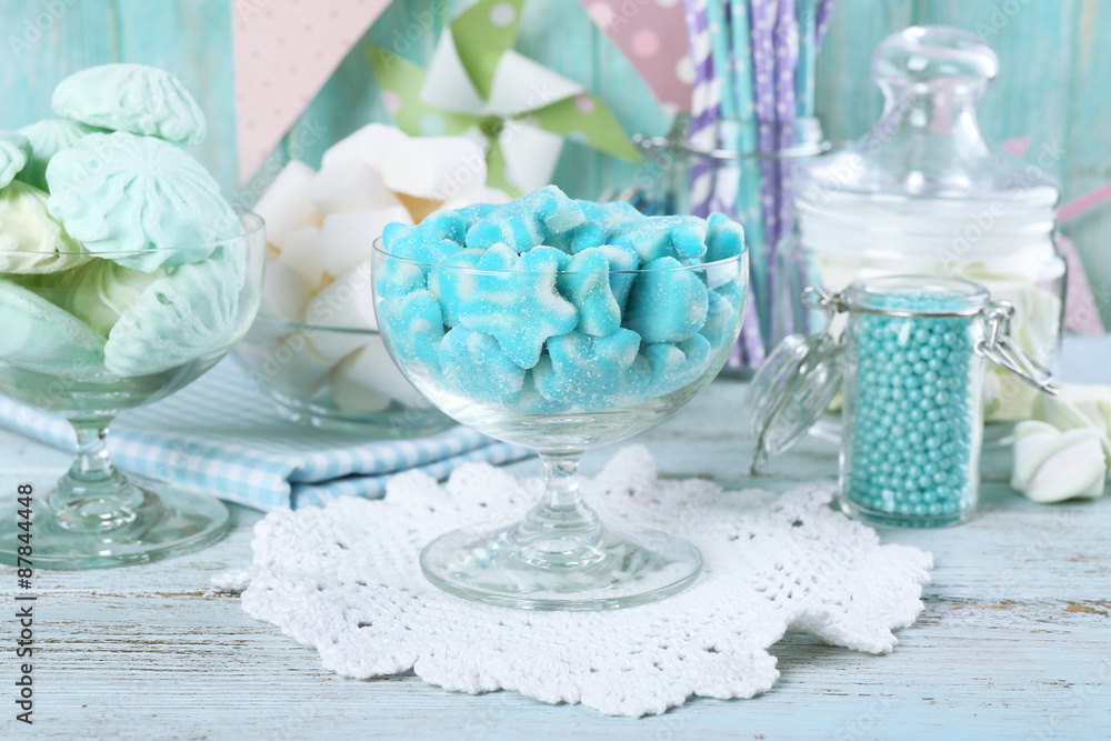 Sweet candies in glassware on wooden table, closeup Sweet candies in glassware on wooden table, closeup