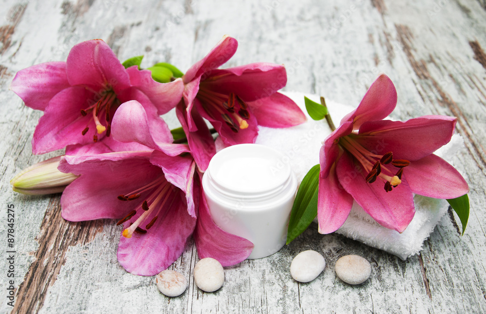 cosmetic cream and pink lily flower