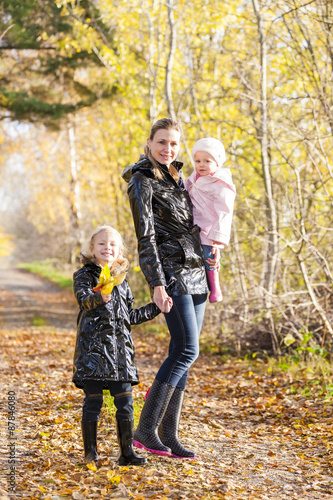 mother with her daughters in autumnal nature