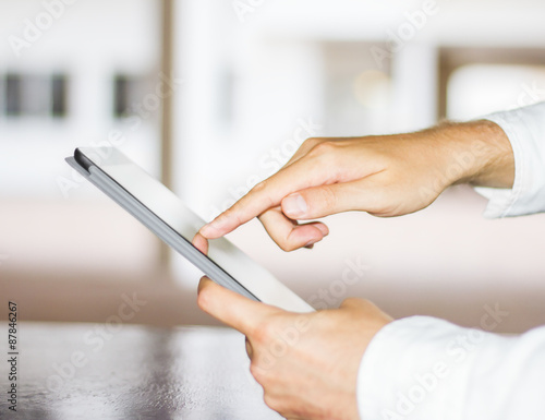 man clicks on a digital tablet