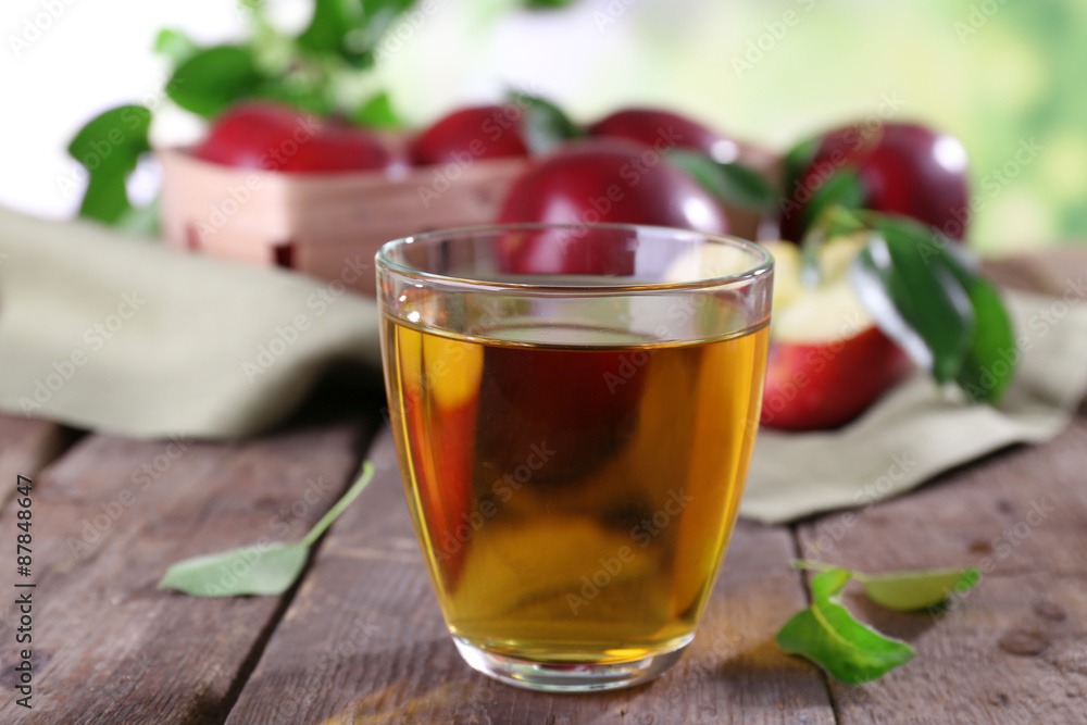 Glass of apple juice with red apples on wooden table, closeup Glass of apple juice with red apples on wooden table, closeup