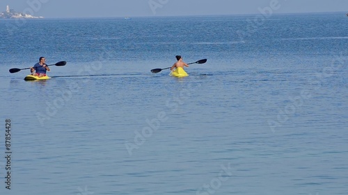 sea kayak. People having fun rowing at open sea photo