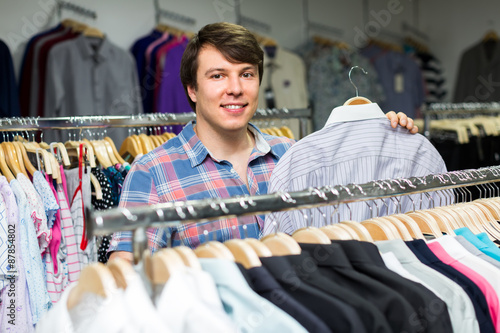 Man choosing shirts in store