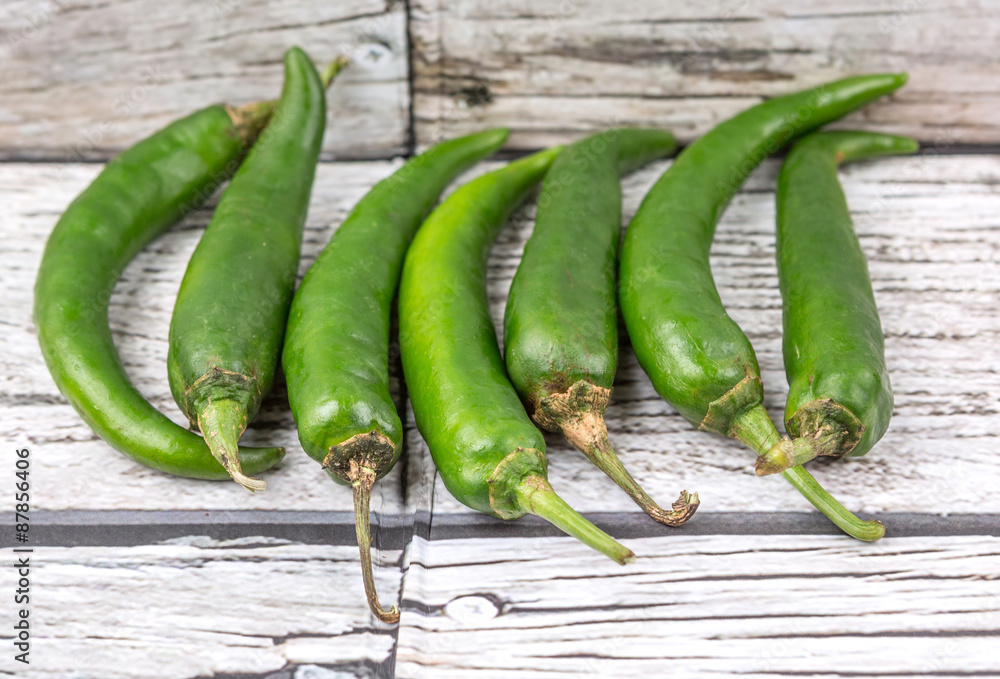 Chili peppers over wooden background Chili peppers over wooden background