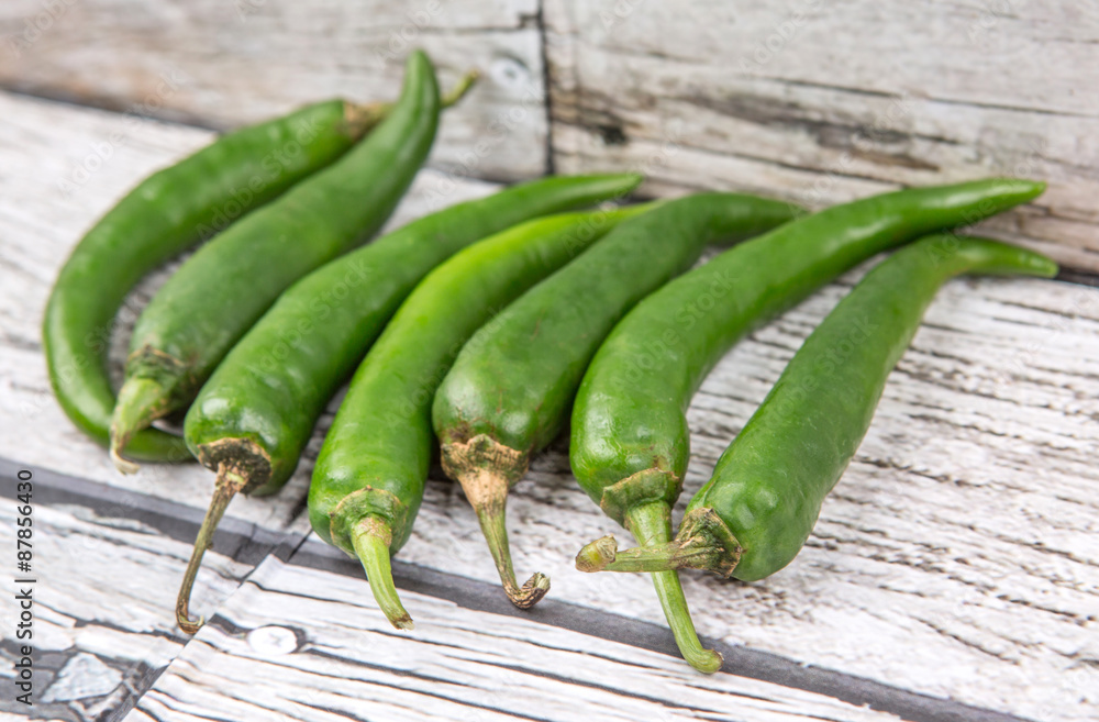 Chili peppers over wooden background Chili peppers over wooden background