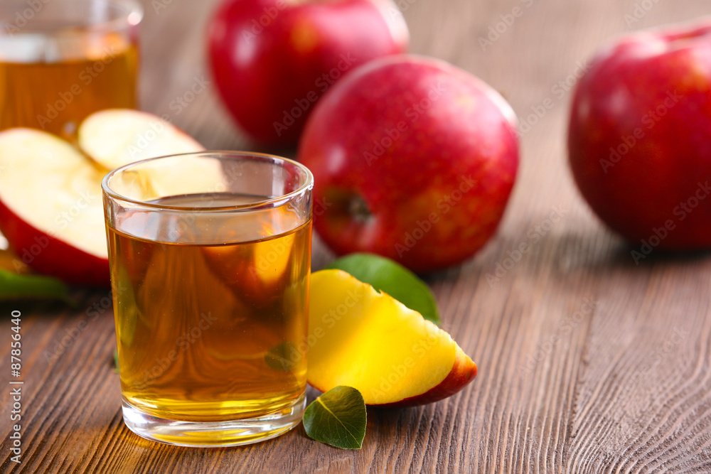 Glasses of apple juice and fruits on table close up Glasses of apple juice and fruits on table close up